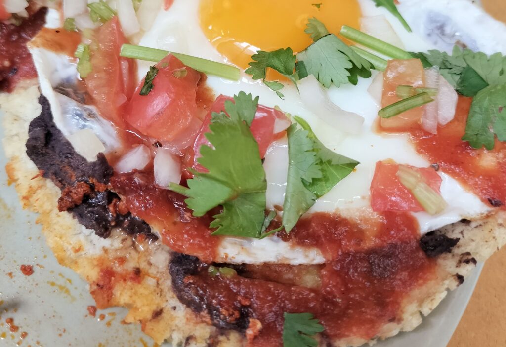 「Huevos Rancheros」のフリホレスとトルティーヤ